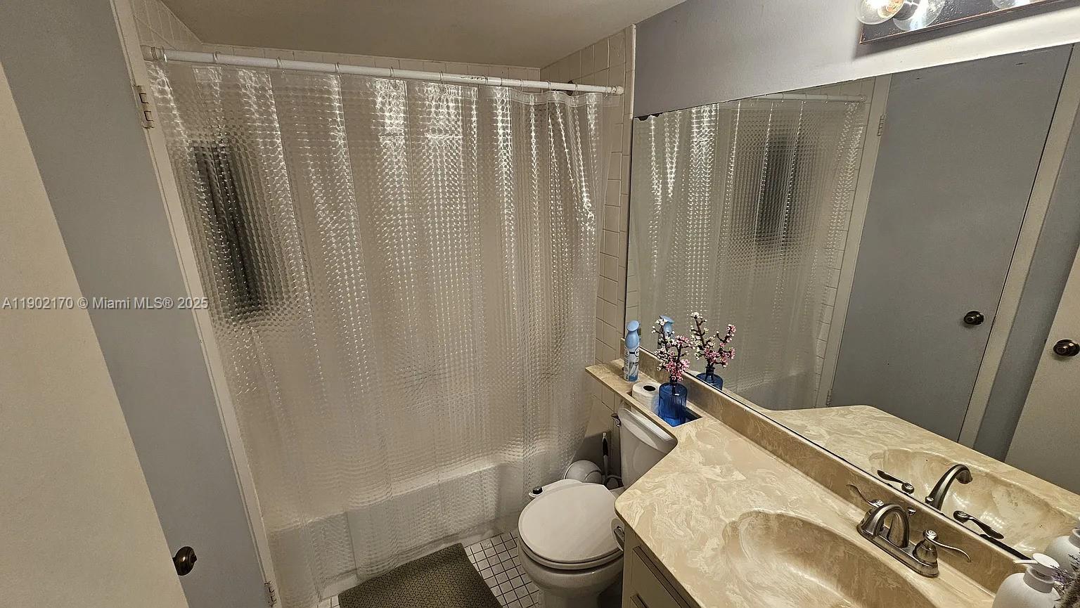 13235 Southwest 110th Terrace, Unit 183 Miami, FL 33186 - Photo 6 of 14 a bathroom with a granite countertop sink toilet and a mirror