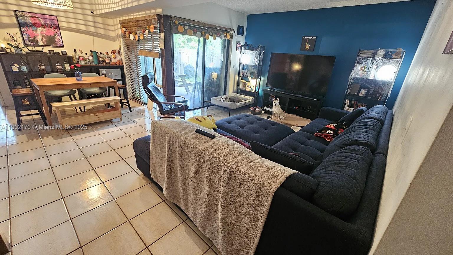 13235 Southwest 110th Terrace, Unit 183 Miami, FL 33186 - Photo 8 of 14 a living room with furniture and a flat screen tv