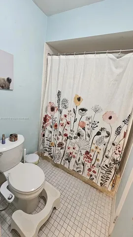 a white toilet sitting next to a shower curtain