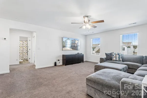 a living room with furniture and a ceiling fan