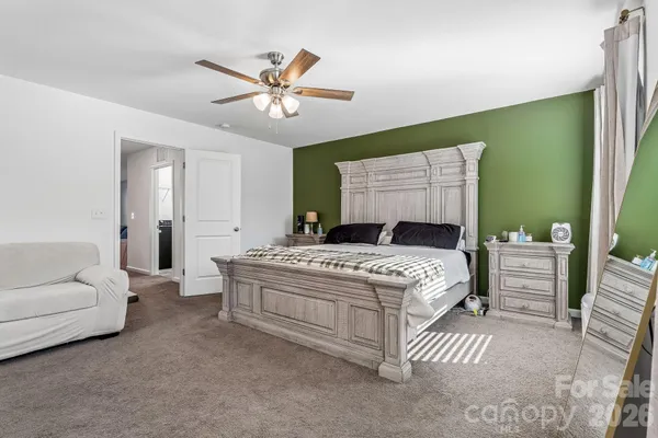 a bedroom with a large bed and a chandelier