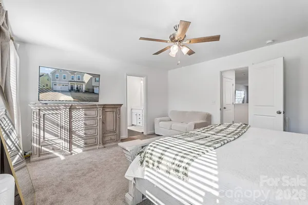 a bedroom with a bed a dresser and a chandelier