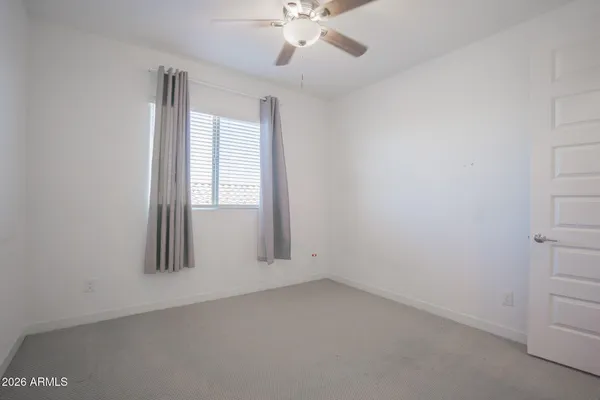 an empty room with windows and fan