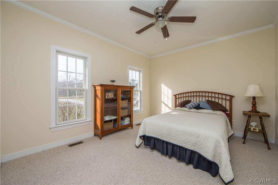 16840 Loving Union Road Disputanta, VA 23842 - Photo 18 of 35 a bedroom with a bed a dresser and a window