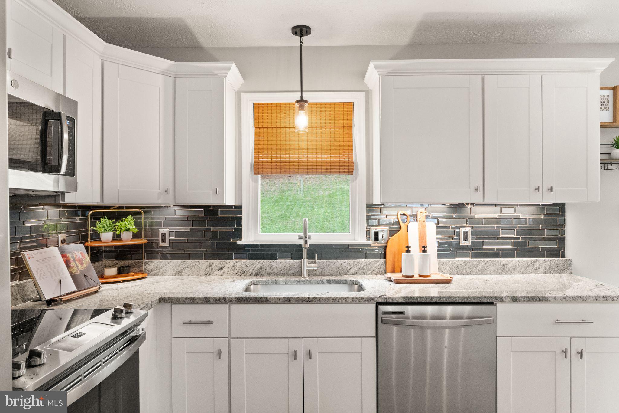 413 George Street Winchester, VA 22601 - Photo 13 of 54 a kitchen with stainless steel appliances granite countertop a sink a stove a microwave a counter space and cabinets