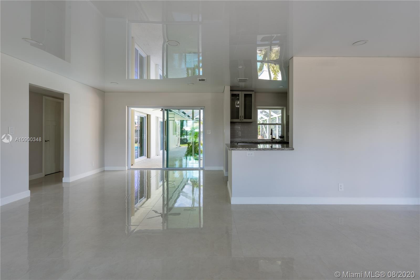 2630 Northeast 51st Court Lighthouse Point, FL 33064 - Photo 11 of 43 a view of a hallway with wooden floor and a livingroom