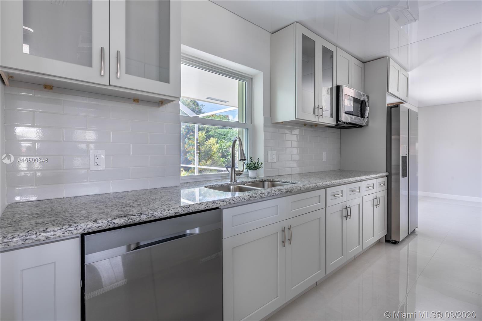 2630 Northeast 51st Court Lighthouse Point, FL 33064 - Photo 19 of 43 a kitchen with stainless steel appliances granite countertop a sink dishwasher a stove and a granite counter tops