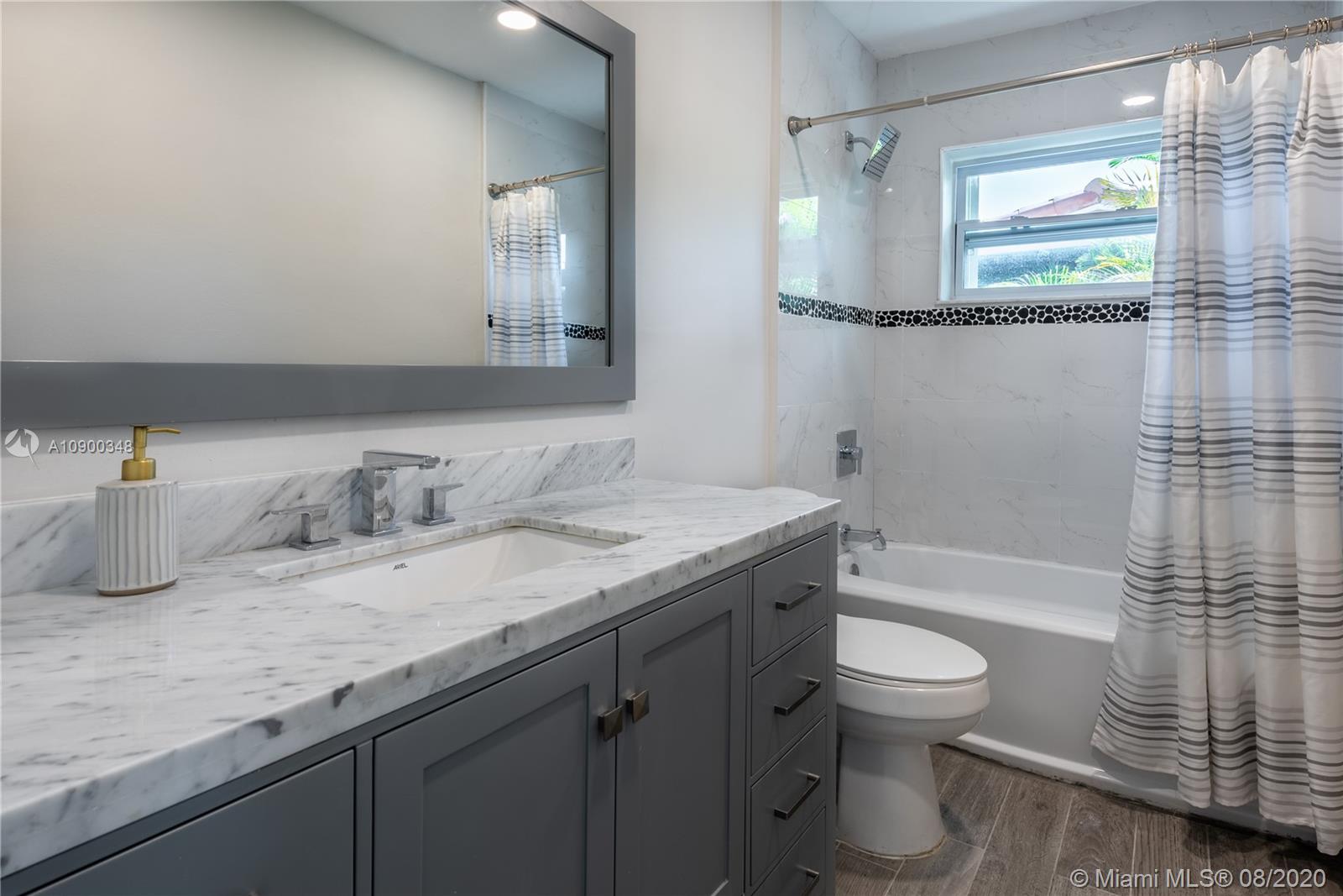 2630 Northeast 51st Court Lighthouse Point, FL 33064 - Photo 24 of 43 a bathroom with a granite countertop sink toilet and shower