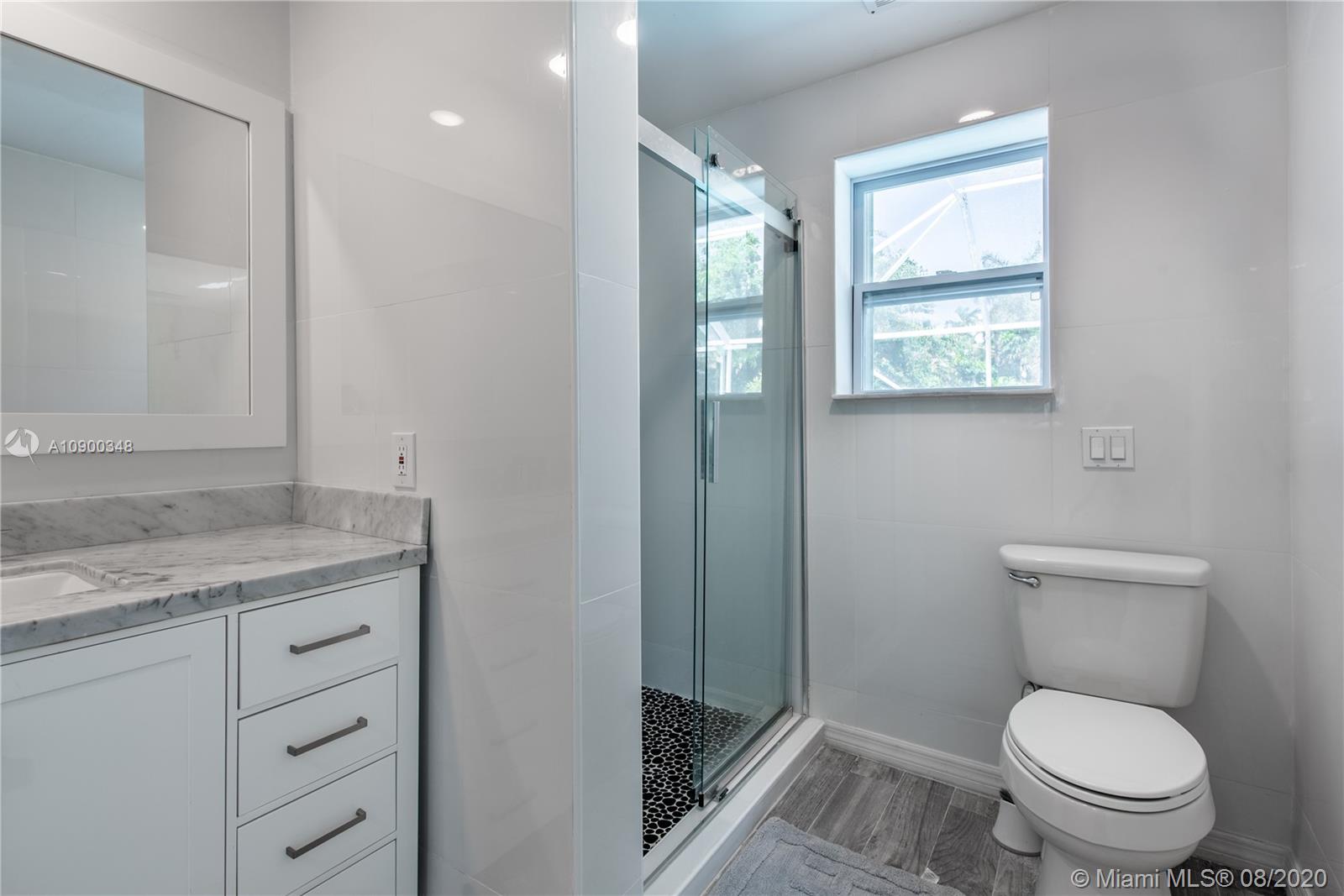 2630 Northeast 51st Court Lighthouse Point, FL 33064 - Photo 31 of 43 a bathroom with a granite countertop toilet a sink and a mirror