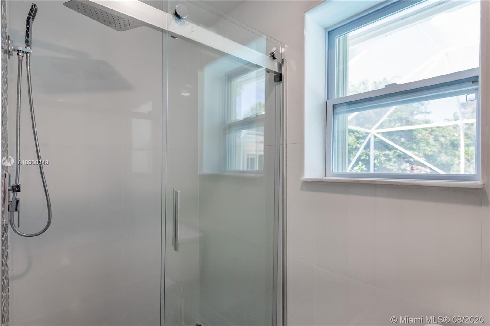 2630 Northeast 51st Court Lighthouse Point, FL 33064 - Photo 33 of 43 a bathroom with a glass shower door