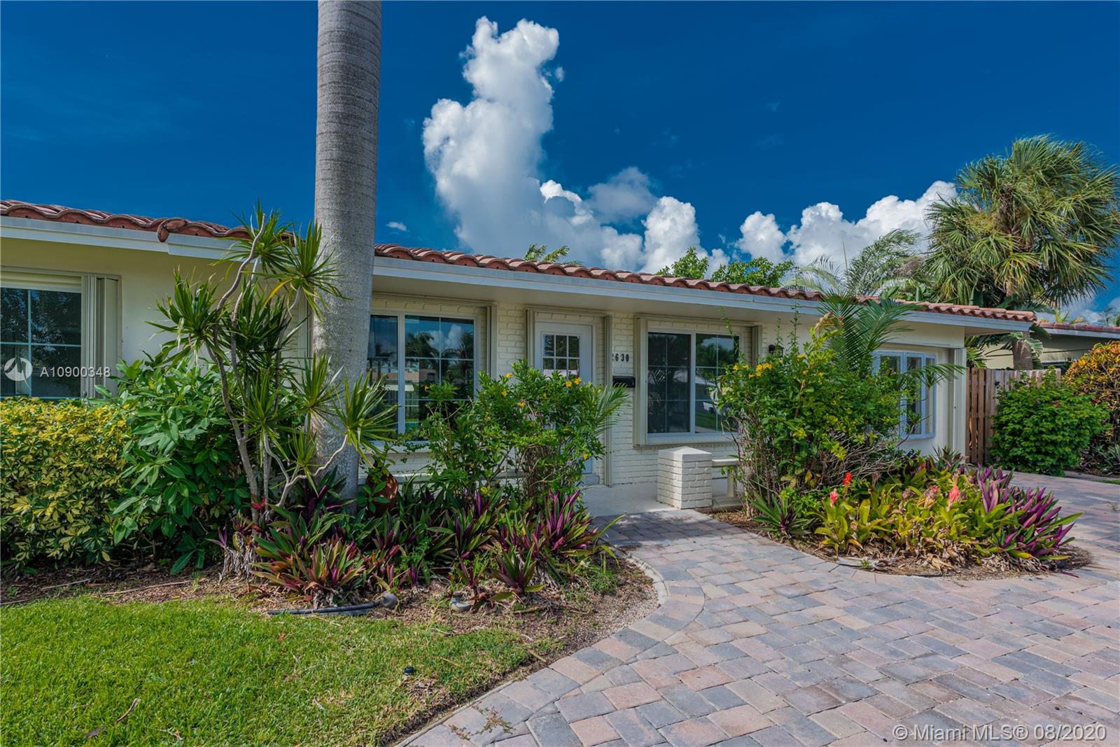 2630 Northeast 51st Court Lighthouse Point, FL 33064 - Photo 4 of 43 a front view of a house with a yard