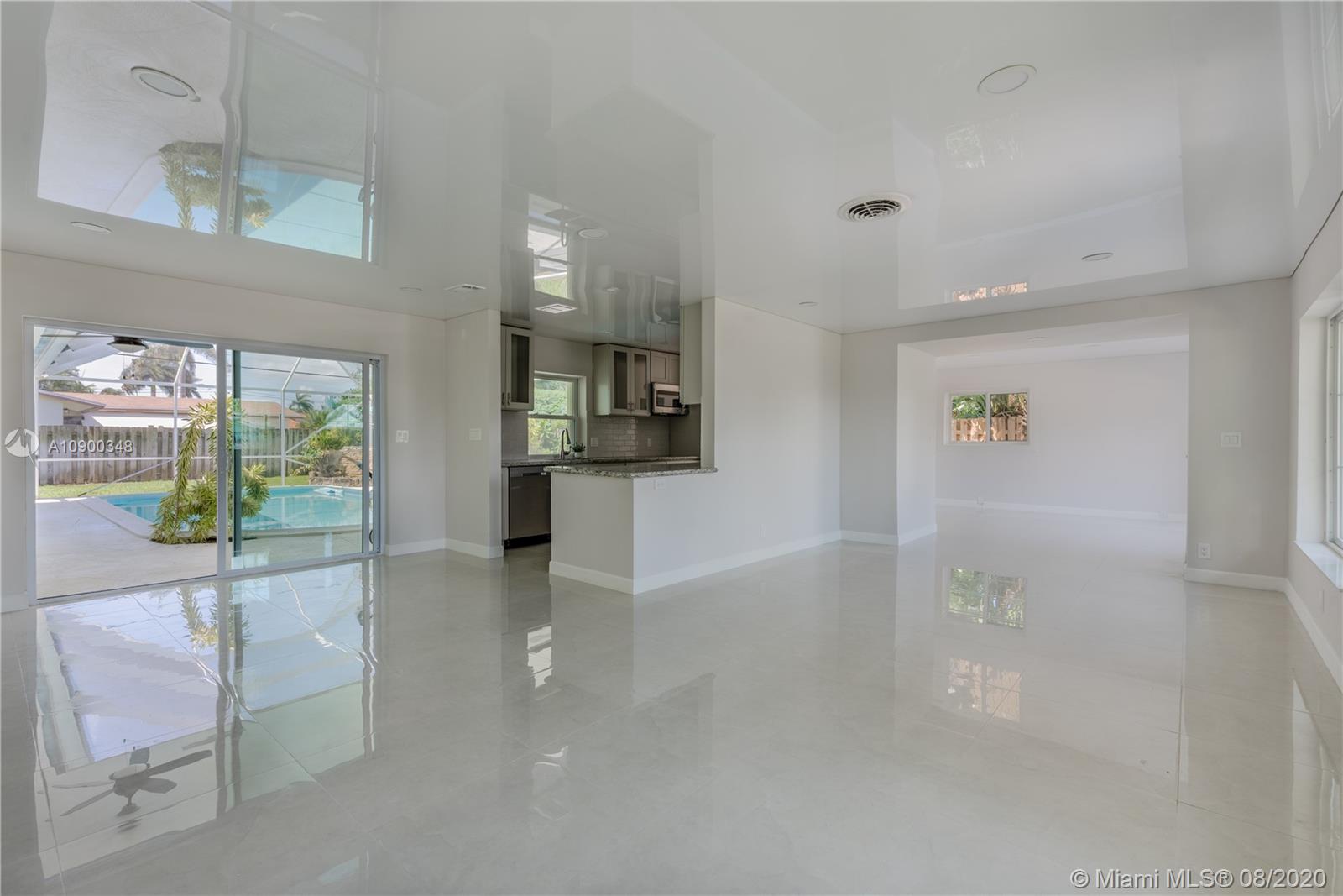 2630 Northeast 51st Court Lighthouse Point, FL 33064 - Photo 10 of 43 a view of a hallway with bathroom and glass door