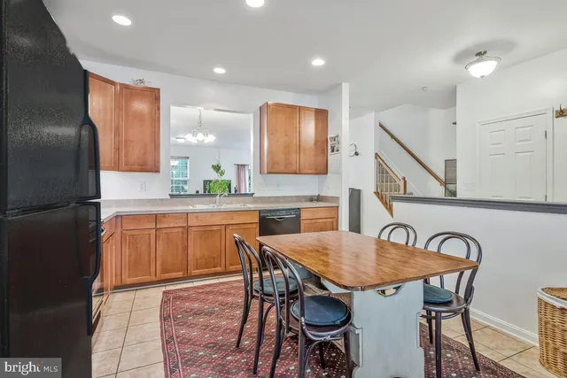 a kitchen with stainless steel appliances granite countertop a kitchen island a table and chairs in it