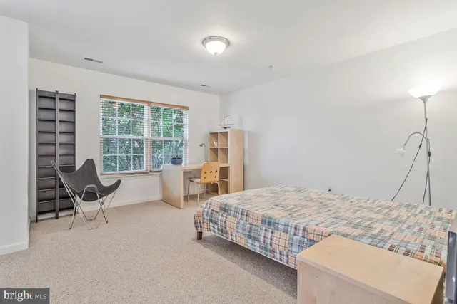 a bedroom with a bed and a large window