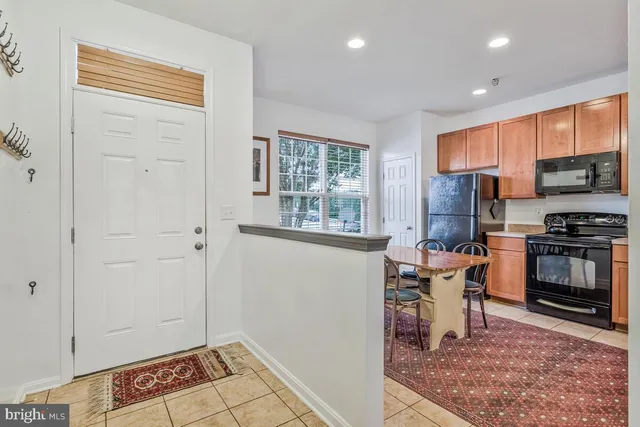 a kitchen with stainless steel appliances granite countertop a stove a sink and a refrigerator with wooden floor