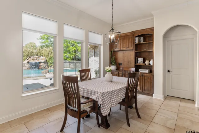 a dining room with furniture a chandelier and window