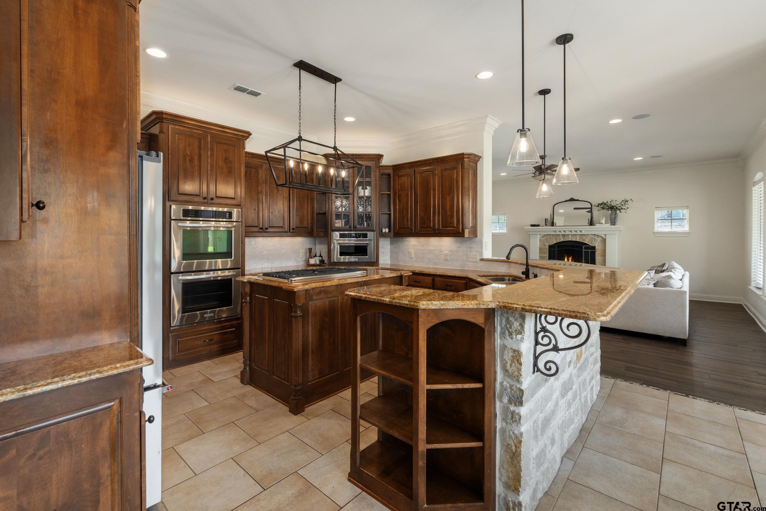 1509 Cooks Crossing Tyler, TX 75703 - Photo 16 of 48 a kitchen with kitchen island a stove a sink and refrigerator