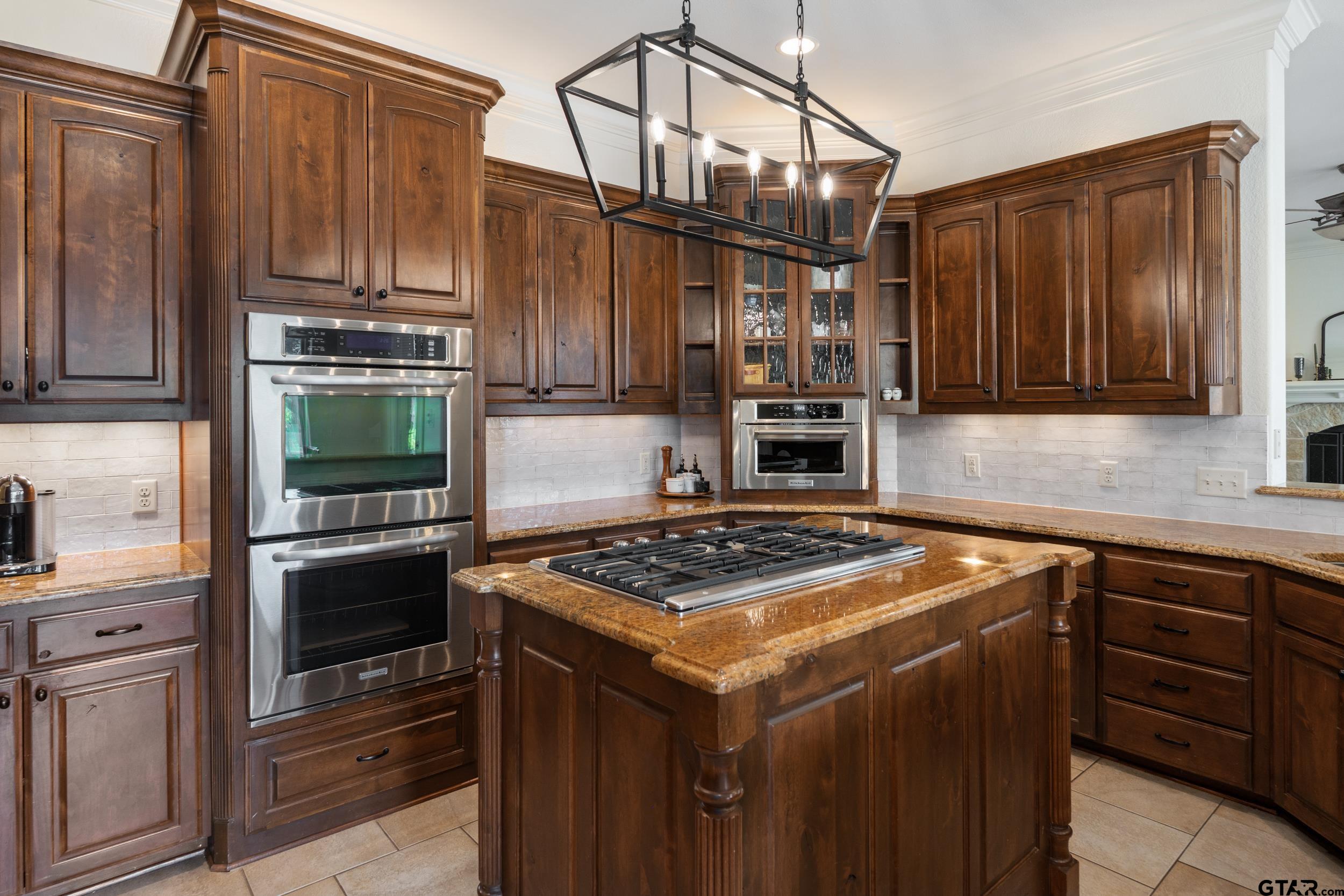 1509 Cooks Crossing Tyler, TX 75703 - Photo 17 of 48 a kitchen with stainless steel appliances granite countertop a stove microwave and refrigerator