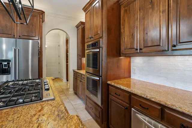 a kitchen with stainless steel appliances granite countertop a refrigerator and a sink