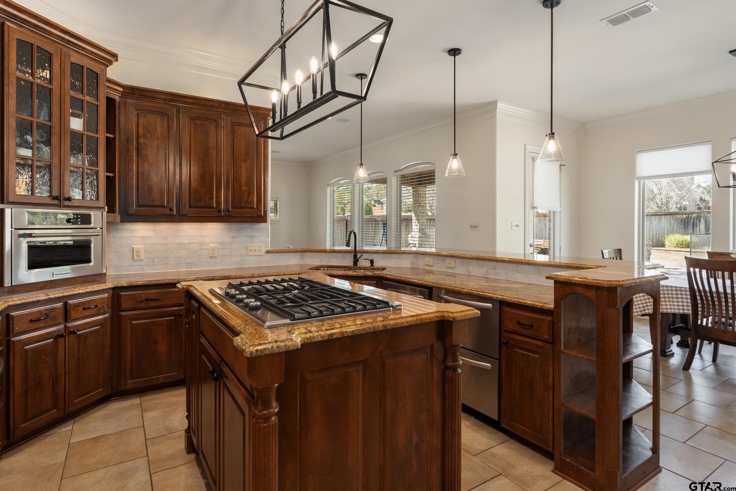 1509 Cooks Crossing Tyler, TX 75703 - Photo 20 of 48 a kitchen with stainless steel appliances granite countertop a stove a sink and a wooden cabinets