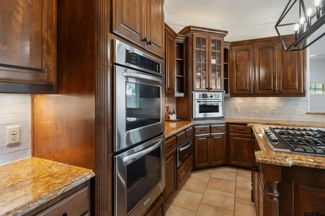 a kitchen with granite countertop a stove and cabinets
