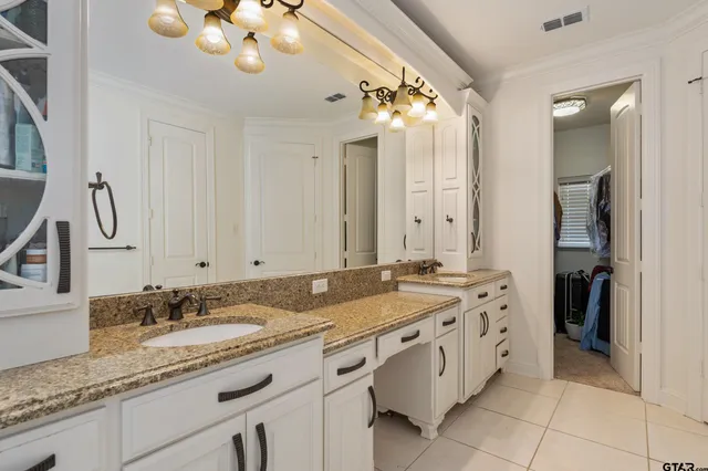 a spacious bathroom with a granite countertop double vanity sink a mirror and a shower