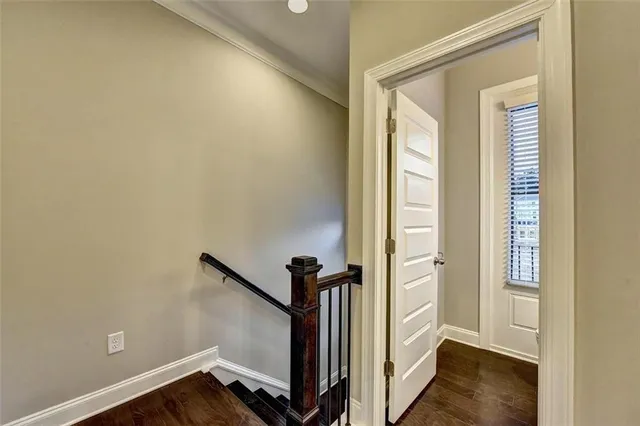 a view of a hallway with wooden floor and stairs