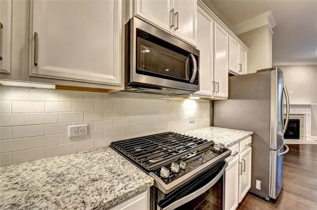 a kitchen with granite countertop a stove and a microwave