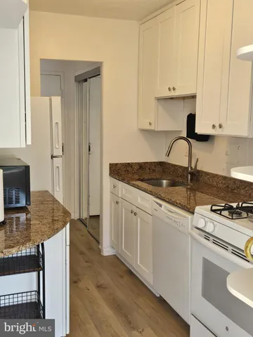 a kitchen with kitchen island granite countertop a sink cabinets and stainless steel appliances