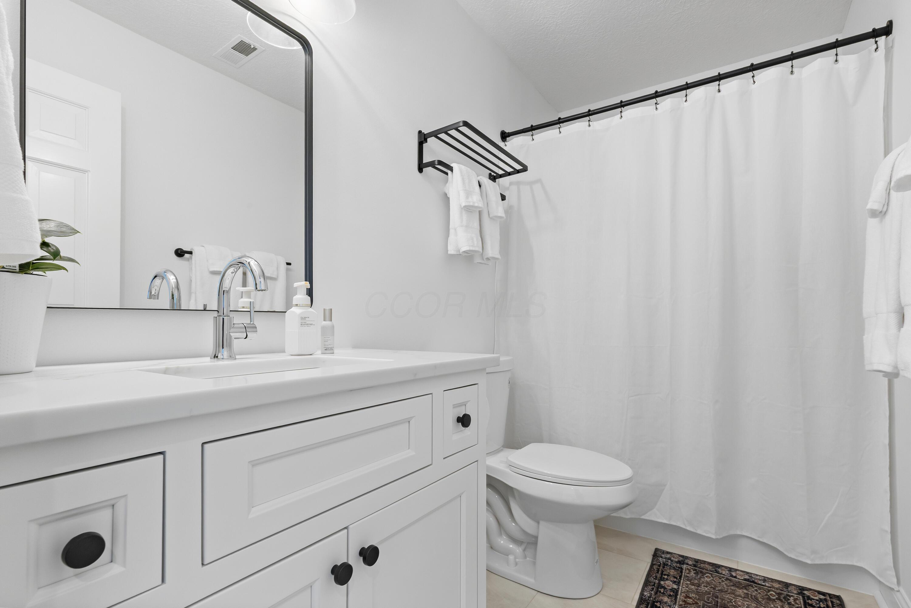 1364 Dale Ford Road Delaware, OH 43015 - Photo 69 of 112 • Luxury vinyl plank flooring • White painted walls • Custom built enclosed vanity with single bowl, quartz sinktop • 3 bulb wall light • Tub/shower combination with acrylic surround • Ceiling exhaust • Mirror remains
