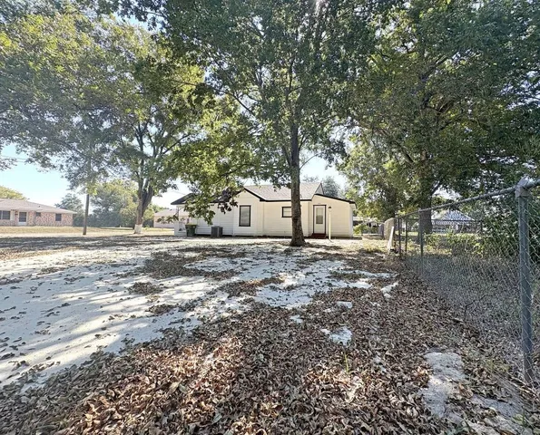 a view of a yard with a house and a large tree