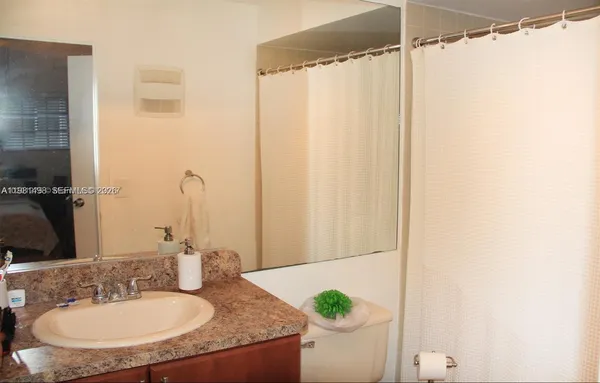 a bathroom with a granite countertop sink and a mirror