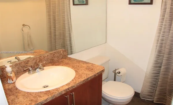 a bathroom with a granite countertop sink and a mirror