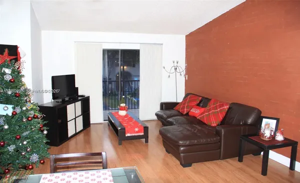 a living room with furniture a flat screen tv and a potted plant