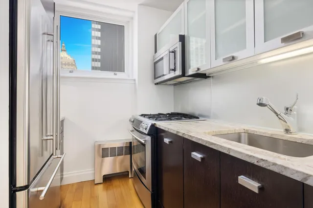 a living room with furniture a flat screen tv and kitchen view