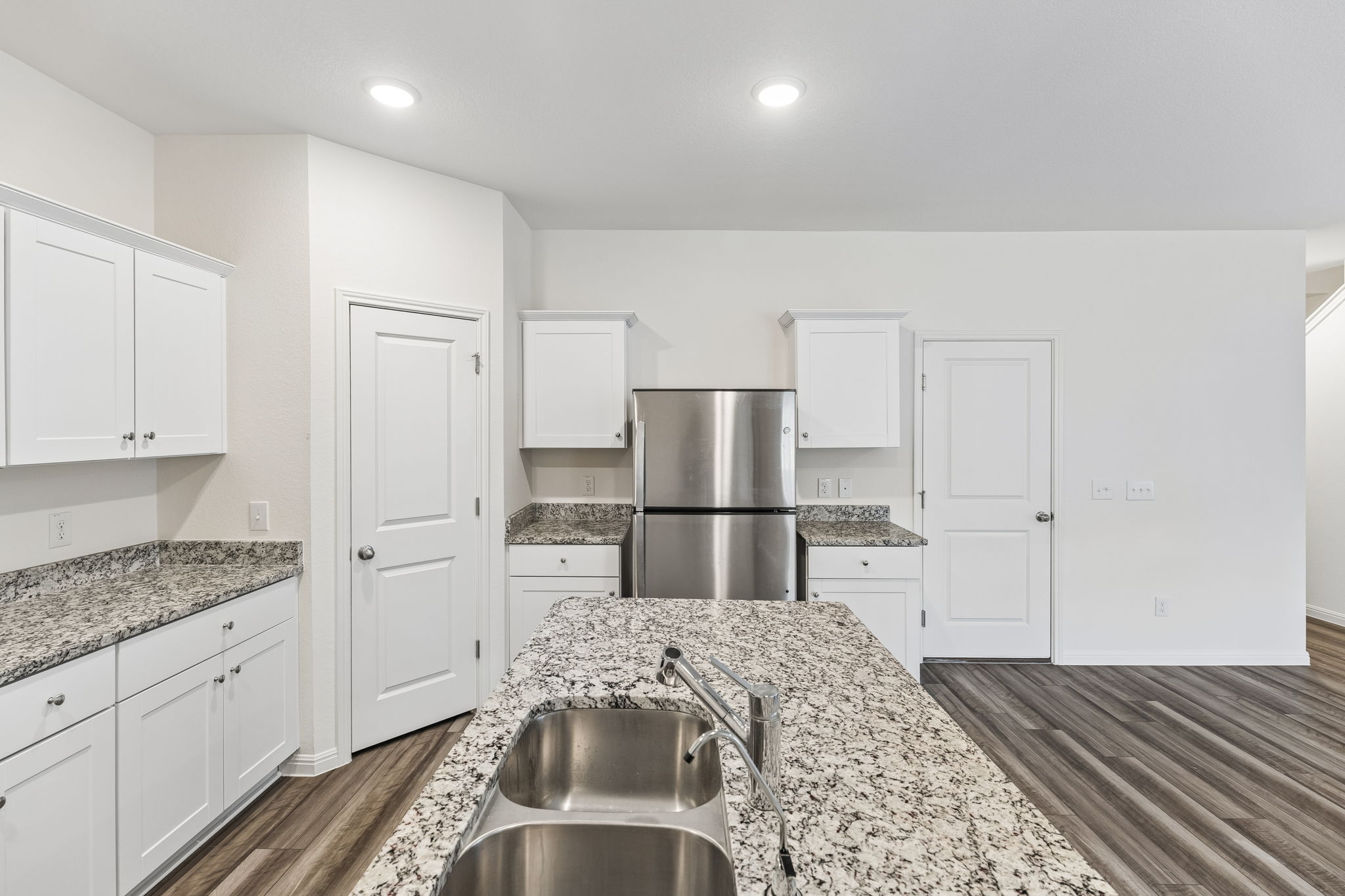 550 Thistle Lane Maxwell, TX 78656 - Photo 8 of 29 Kitchen with white cabinetry, freestanding refrigerator, dark wood-type flooring, light stone counters, and recessed lighting