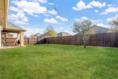 a view of a backyard with table and chairs and wooden fence