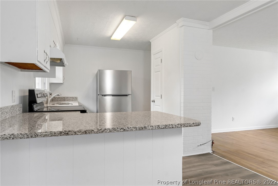77 Hiawatha Road Pembroke, NC 28372 - Photo 14 of 30 a kitchen with kitchen island granite countertop cabinets and refrigerator