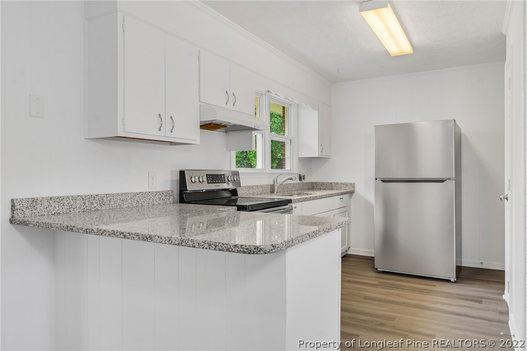 77 Hiawatha Road Pembroke, NC 28372 - Photo 15 of 30 a kitchen with stainless steel appliances granite countertop a refrigerator sink and white cabinets