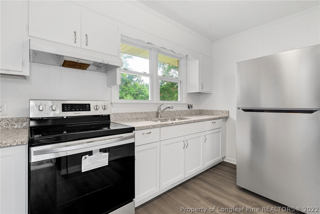 77 Hiawatha Road Pembroke, NC 28372 - Photo 16 of 30 a kitchen with granite countertop white cabinets white stainless steel appliances and sink