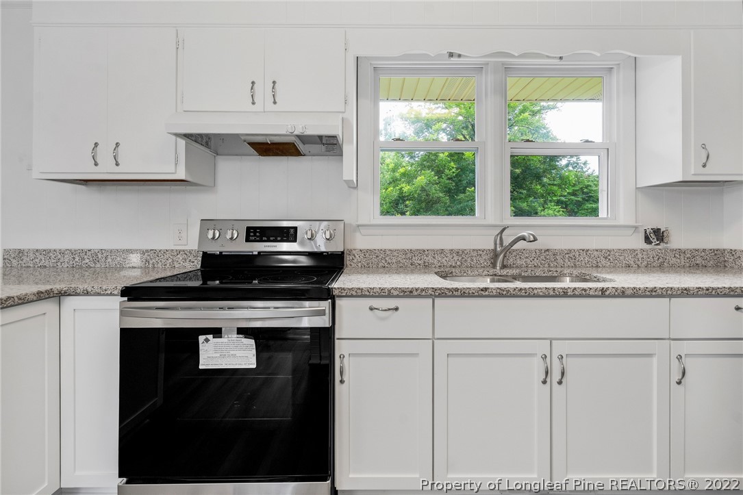 77 Hiawatha Road Pembroke, NC 28372 - Photo 17 of 30 a kitchen with granite countertop white cabinets and a window