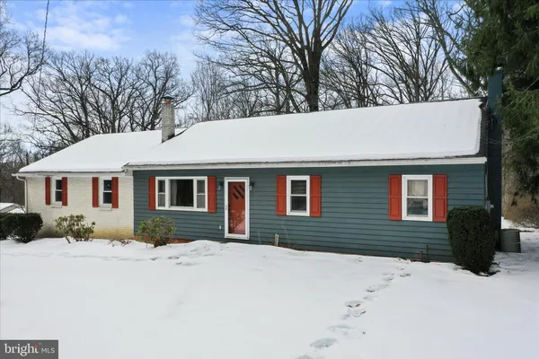 a front view of a house with a yard covered in snow