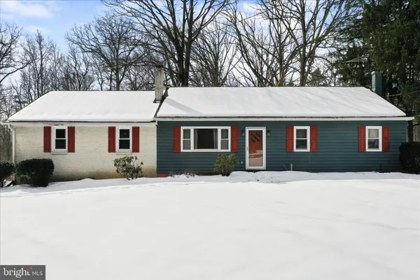 a front view of a house with a yard covered in snow