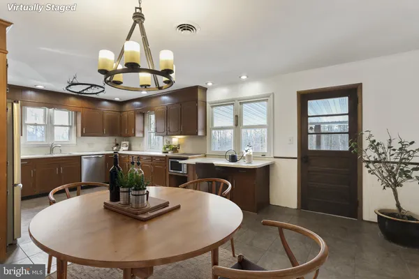 a kitchen with stainless steel appliances a stove a sink cabinets and a wooden floor