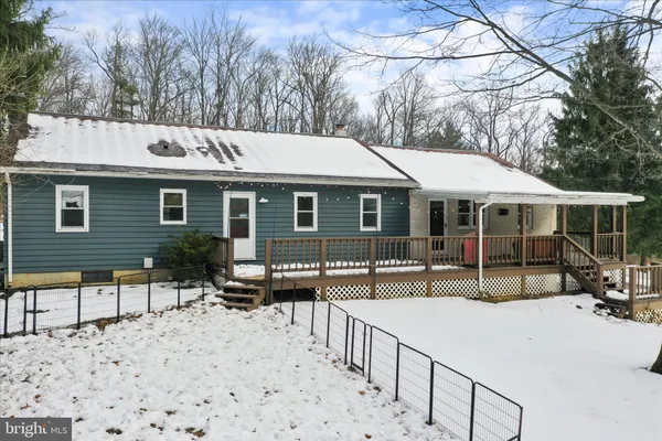 a front view of a house with a yard covered in snow