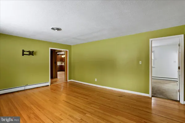 a view of empty room with wooden floor