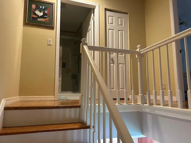 a view of staircase with railing and a window