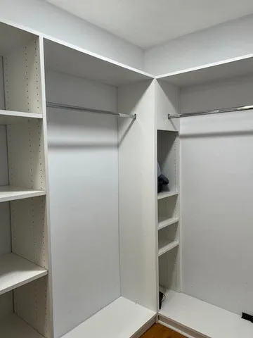 a view of walk in closet with empty racks