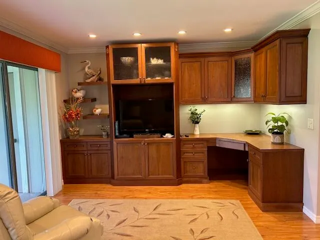 a kitchen with kitchen island granite countertop wooden cabinets a sink a stove a refrigerator and a microwave