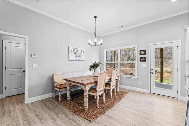 a dining room with furniture window entryway and wooden floor